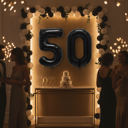 Black 50th birthday party decoration with number balloons